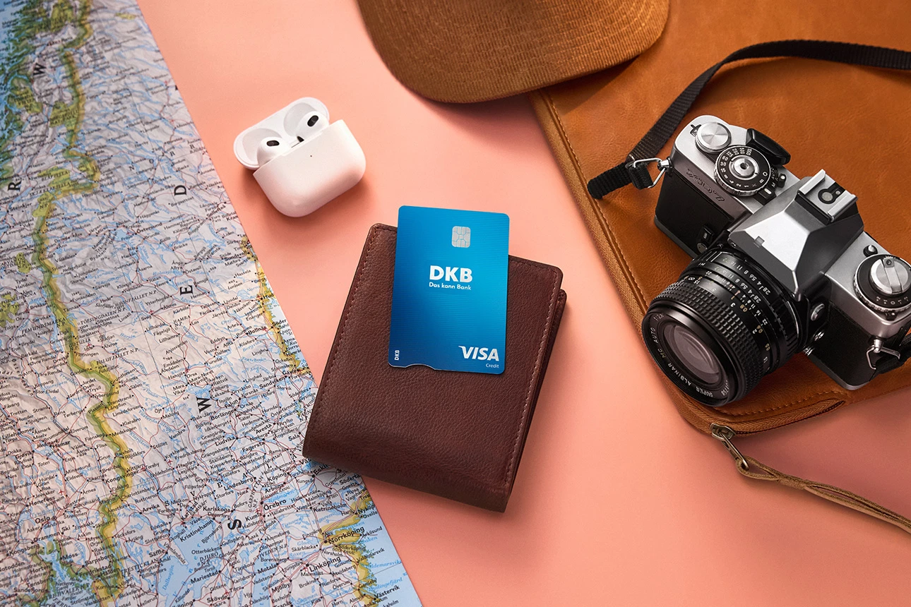 DKB Visa Kreditkarte auf Geldbörse, umgeben von Reiseutensilien