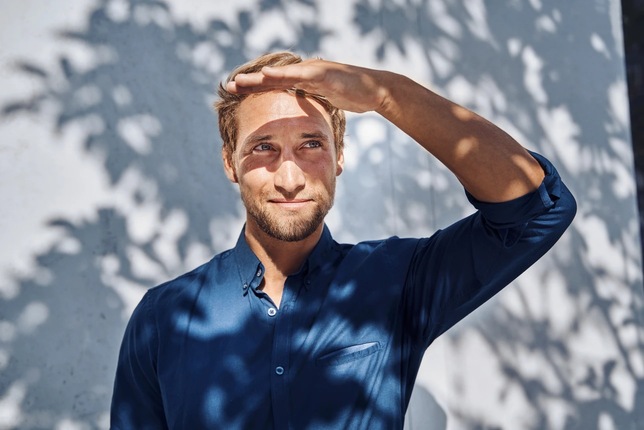 Ein Mann steht im Schatten und blickt in die Ferne