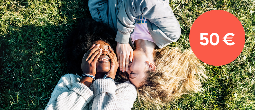 Zwei Frauen liegen auf einer Wiese