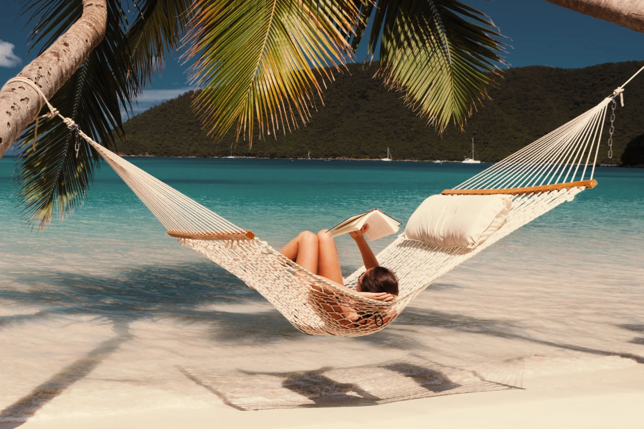 Eine Frau liegt in einer Hängematte am Strand