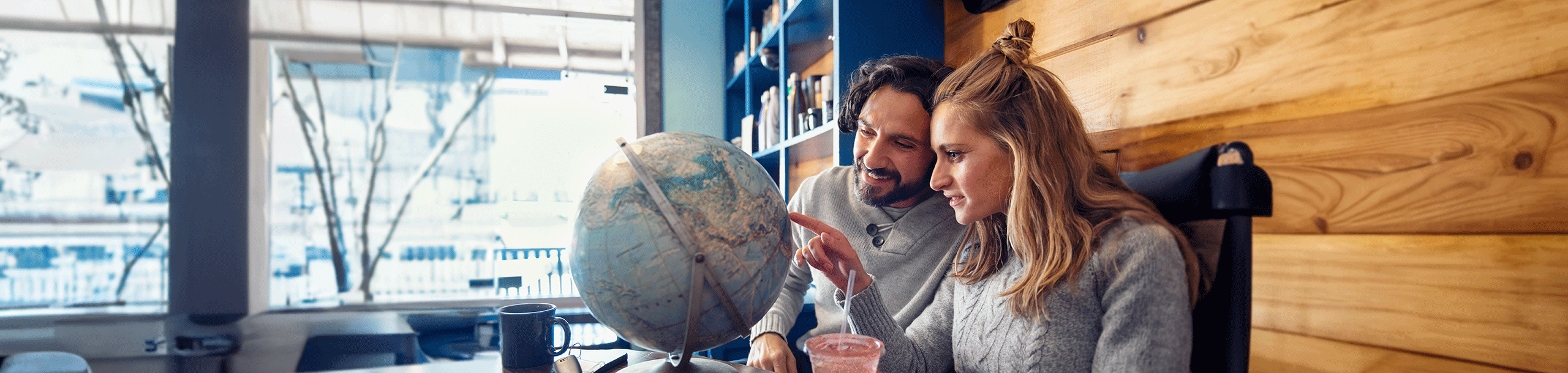 Eine Frau und ein Mann schauen auf einen Globus
