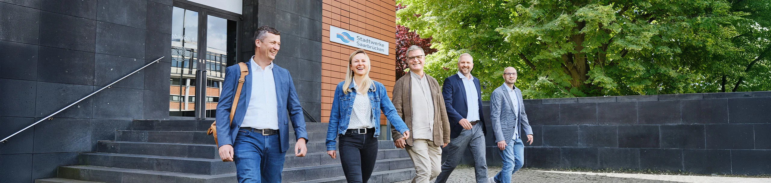 5 Personen kommen aus dem Gebäude der Stadtwerke Saarbrücken gelaufen