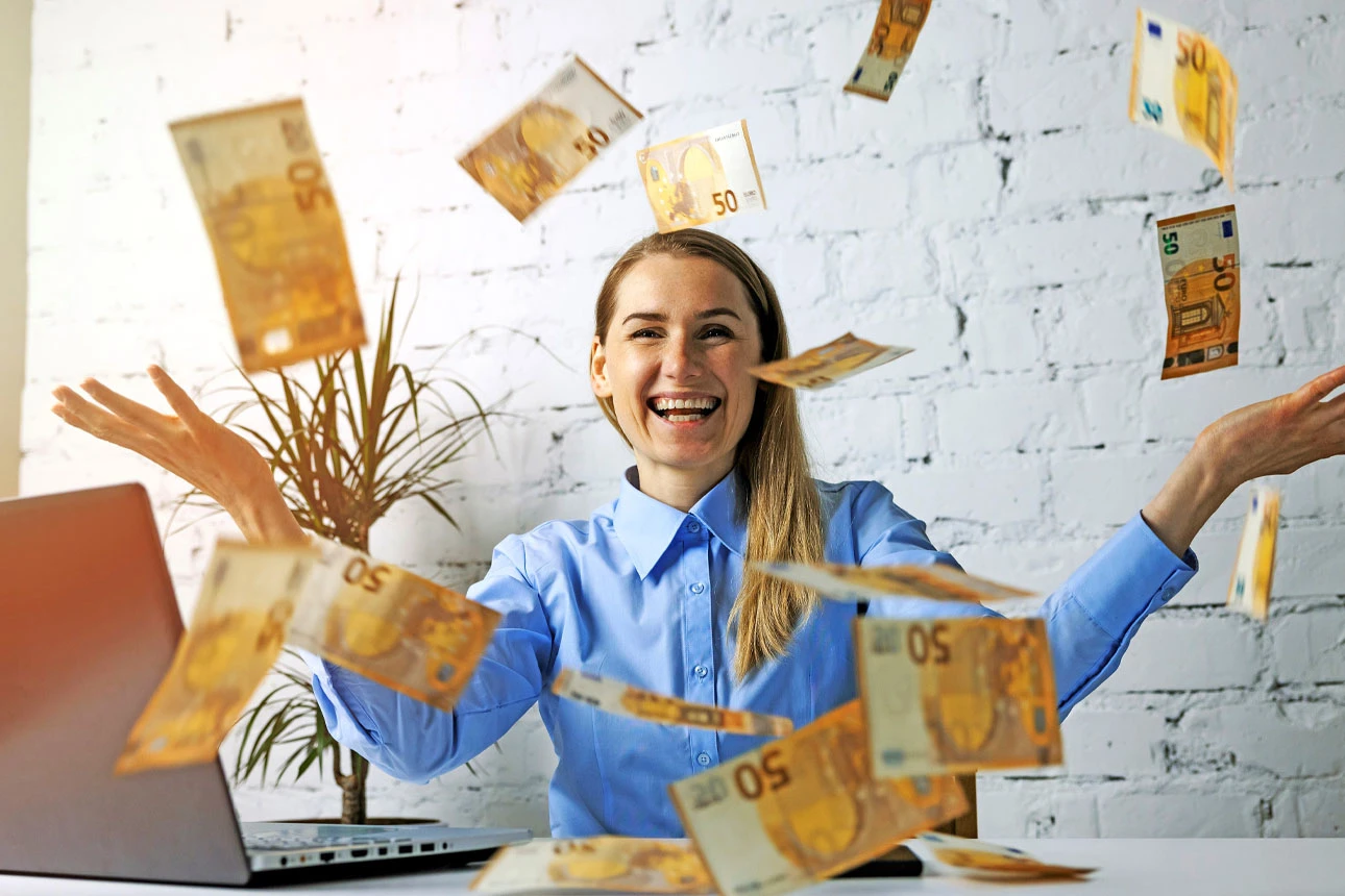 Frau freut sich über einen Geldregen aus 50-Euro-Scheinen.