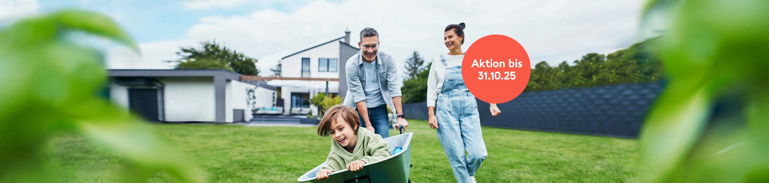 Familie spielt fröhlich im Garten des eigenen Hauses