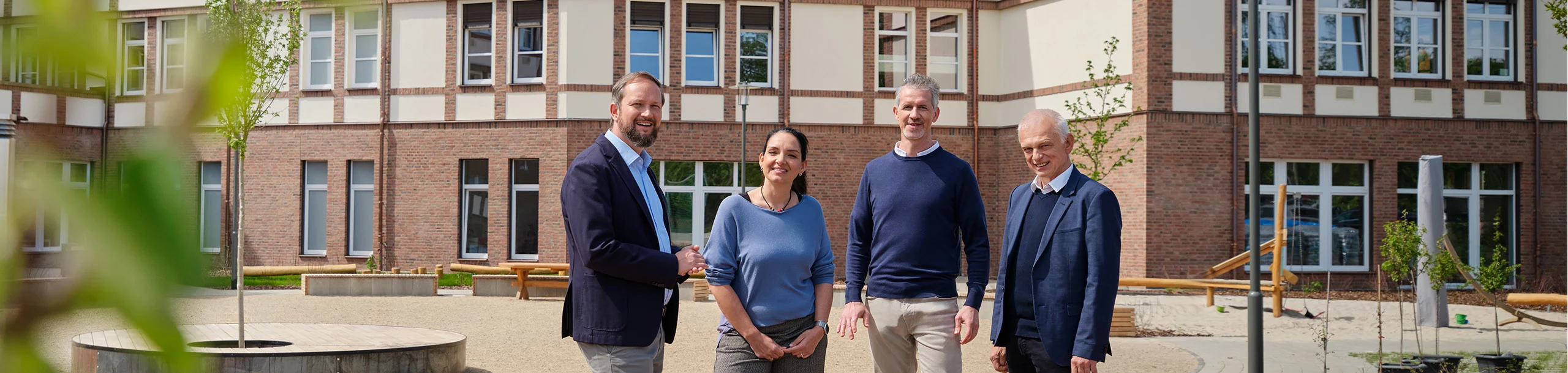 Kund*innen stehen vor dem Schulgebäude