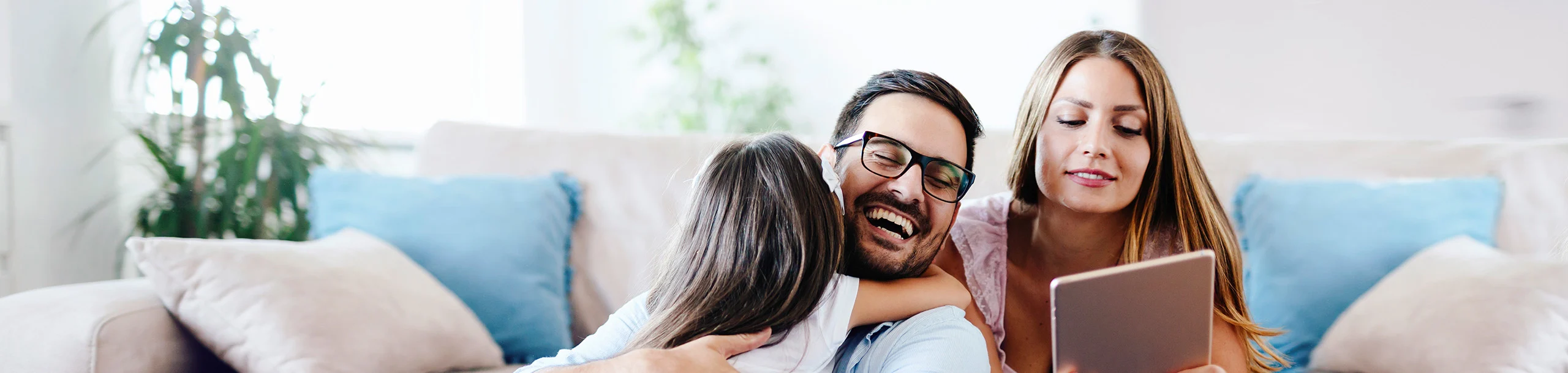 Mädchen umarmt Vater, während Mutter den Sparplan aufsetzt