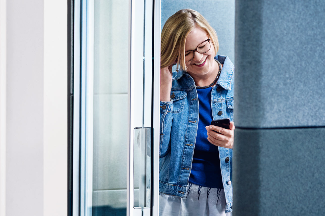 Eine Frau telefoniert im Büro mit Kopfhörern und Handy