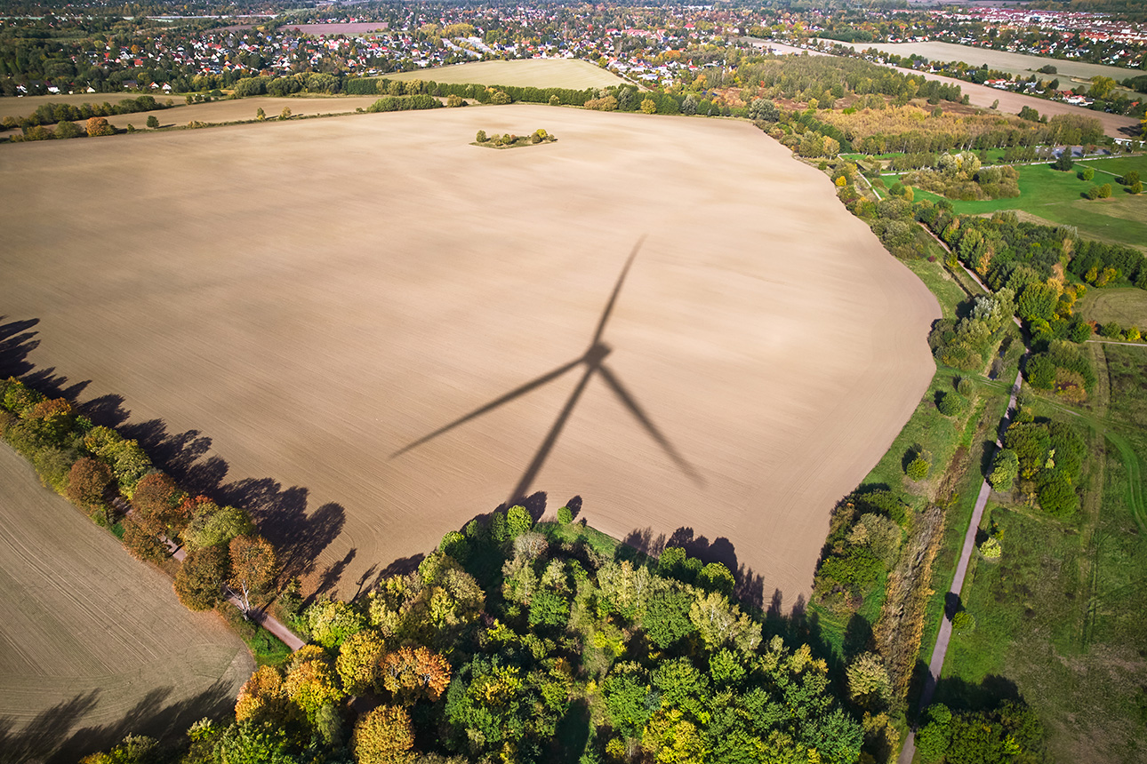 Schatten eines Windrads auf einem Feld