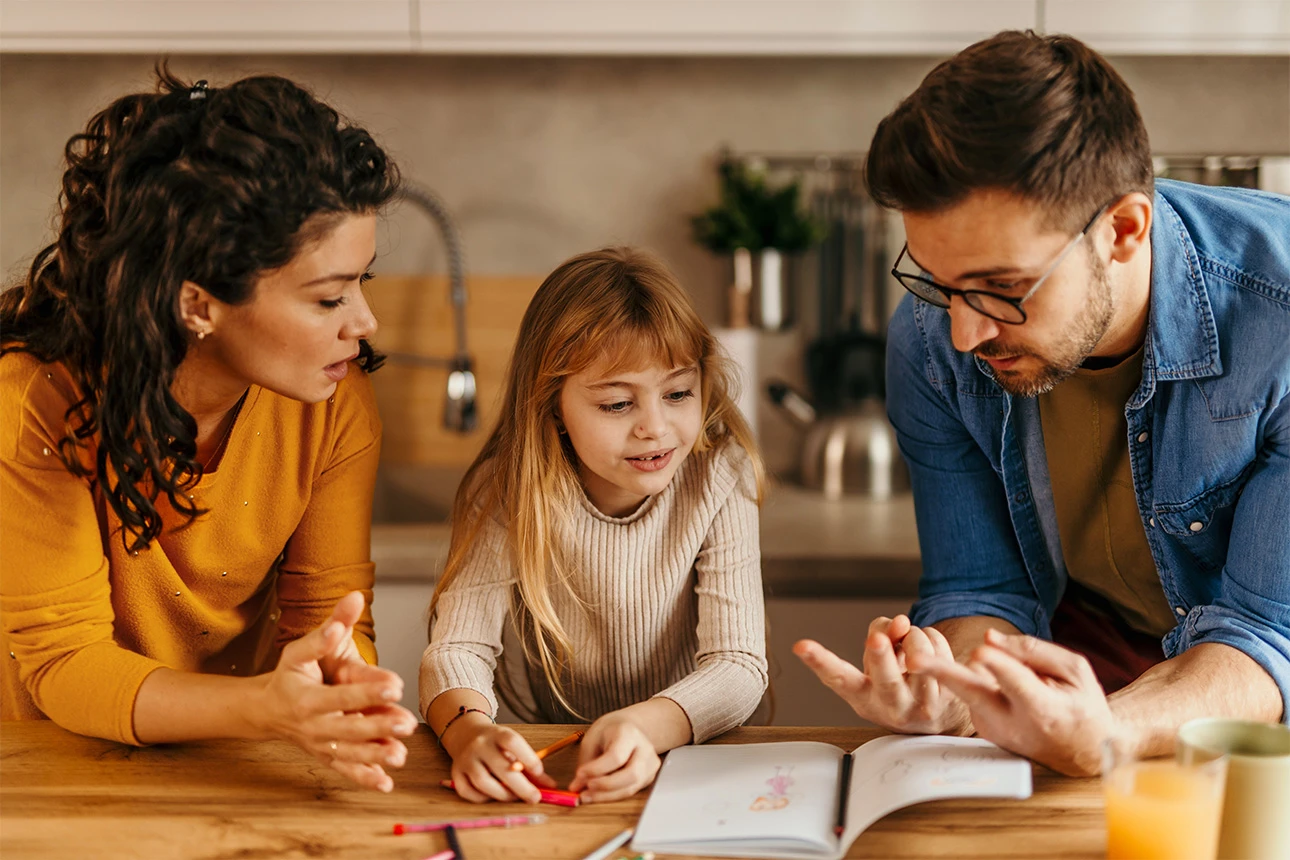 Eine Familie schaut gemeinsam in ein Heft