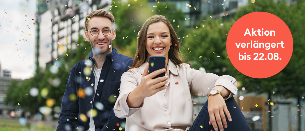 Eine Frau und ein Mann schauen auf ein Smartphone