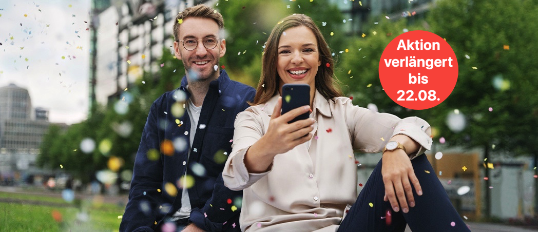 Eine Frau und ein Mann schauen auf ein Smartphone