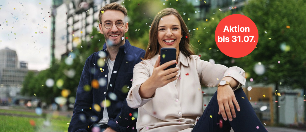 Eine Frau und ein Mann schauen auf ein Smartphone