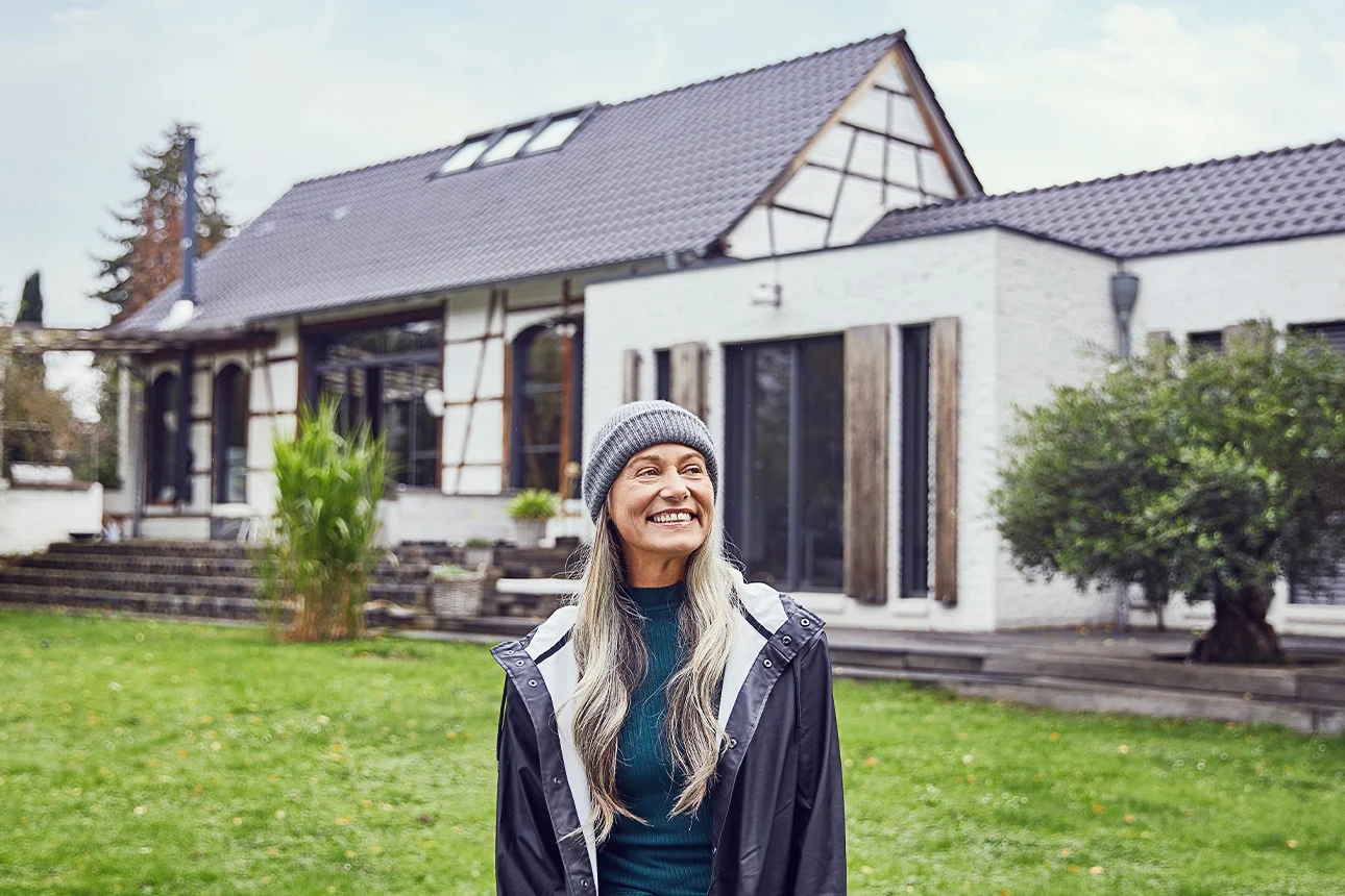 Frau steht vor einem modernisiertem Haus