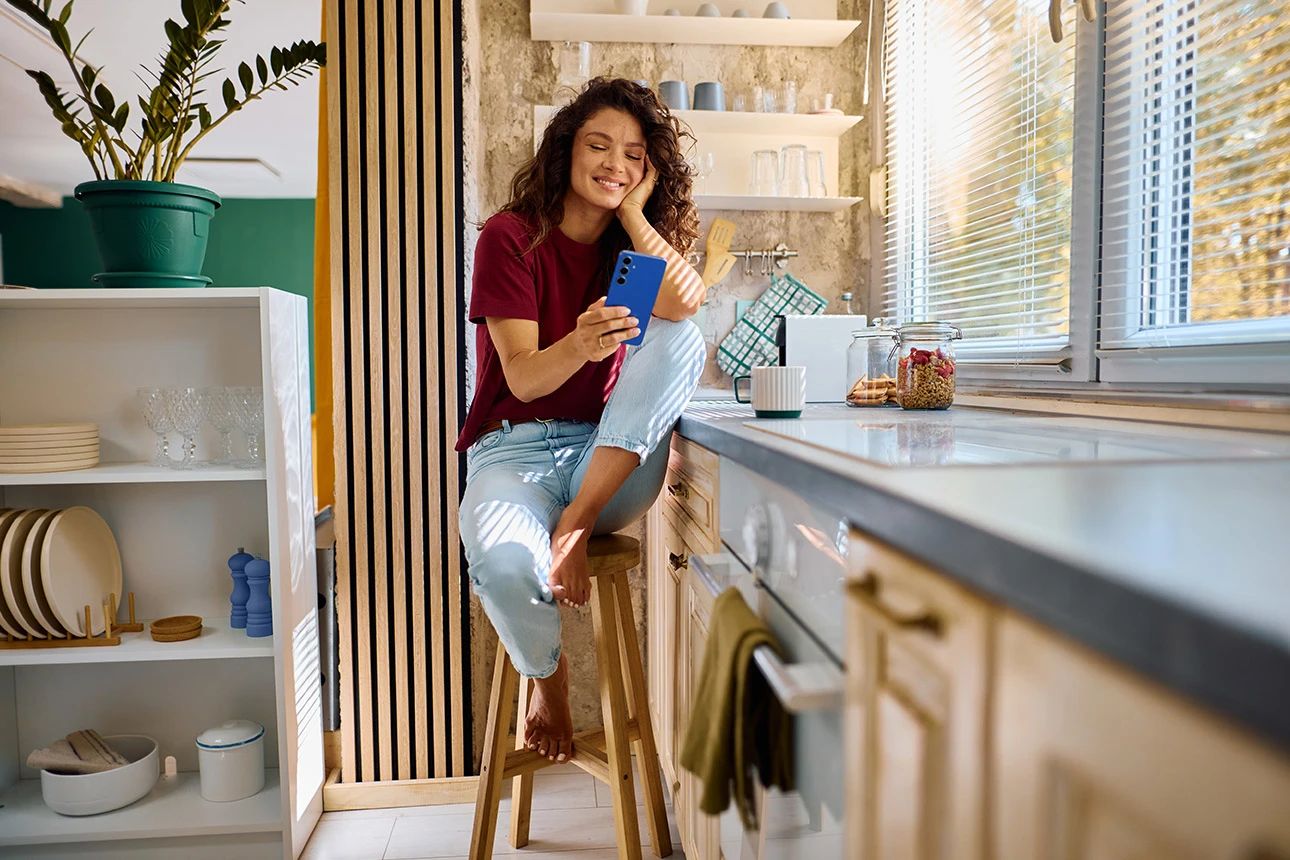 Frau sitzt auf Stuhl und schaut auf ihr Smartphone