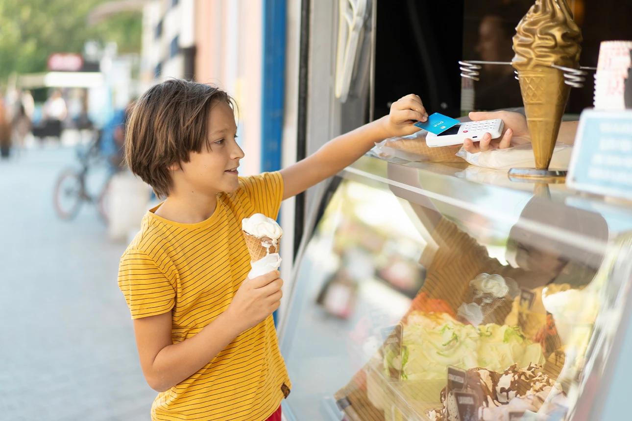 Junge kauft ein Eis.