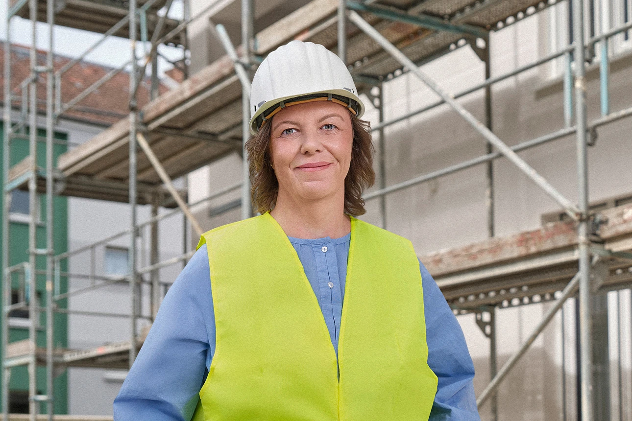 Cora Lehnert von der Wohnbaugenossenschaft vor einem Gebäude