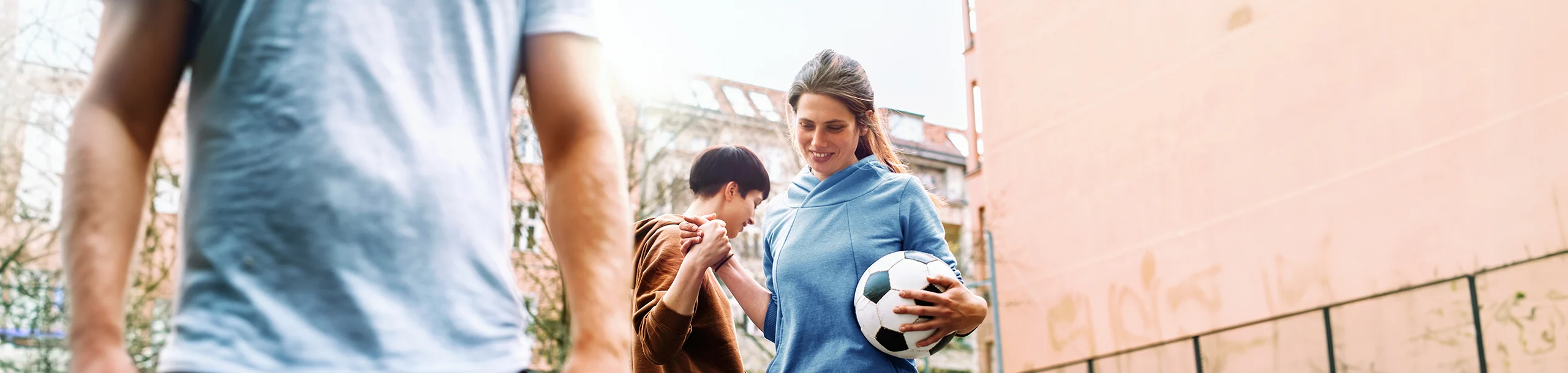 Frau mit Fußball klatscht andere Frau ab