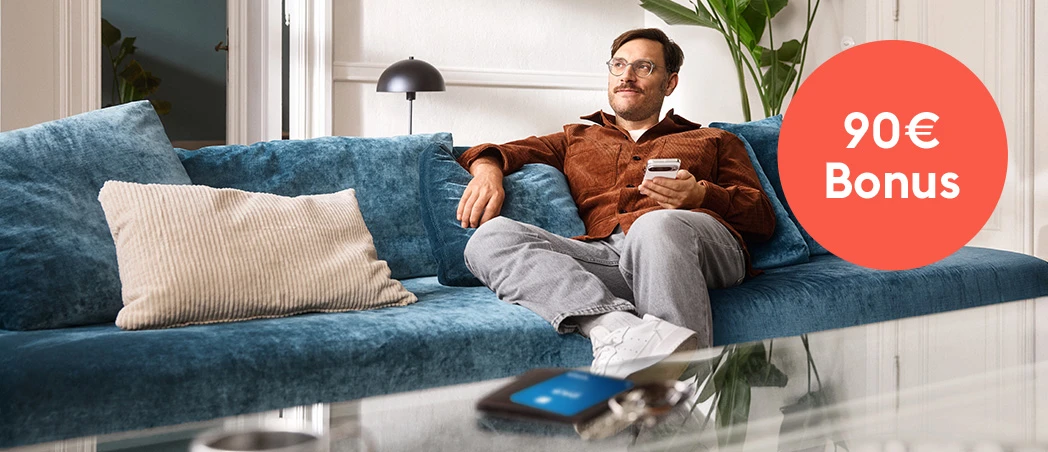 Ein Mann mit Smartphone sitzt auf der Couch