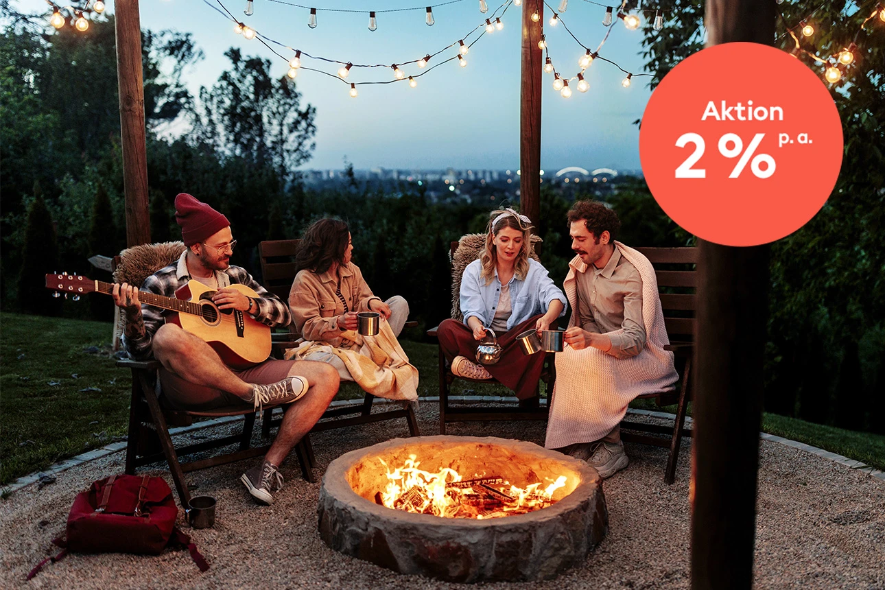 4 Personen sitzen am Lagerfeuer