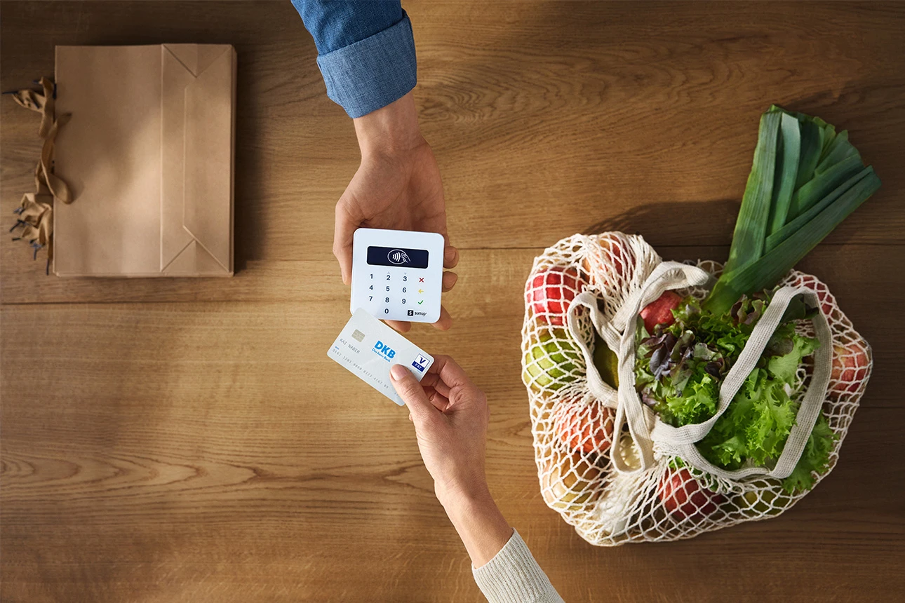 Person bezahlt mit Girokarte am Kartenterminal im Shop
