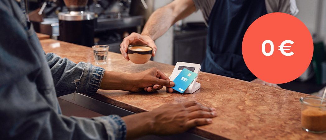 Person bezahlt mit Debitkarte am Kartenterminal im Café