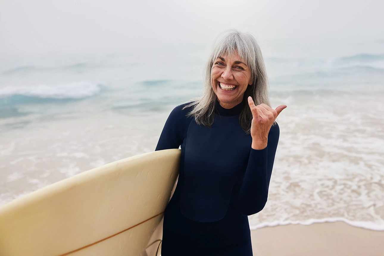 Eine Frau mit Surfbrett am Meer