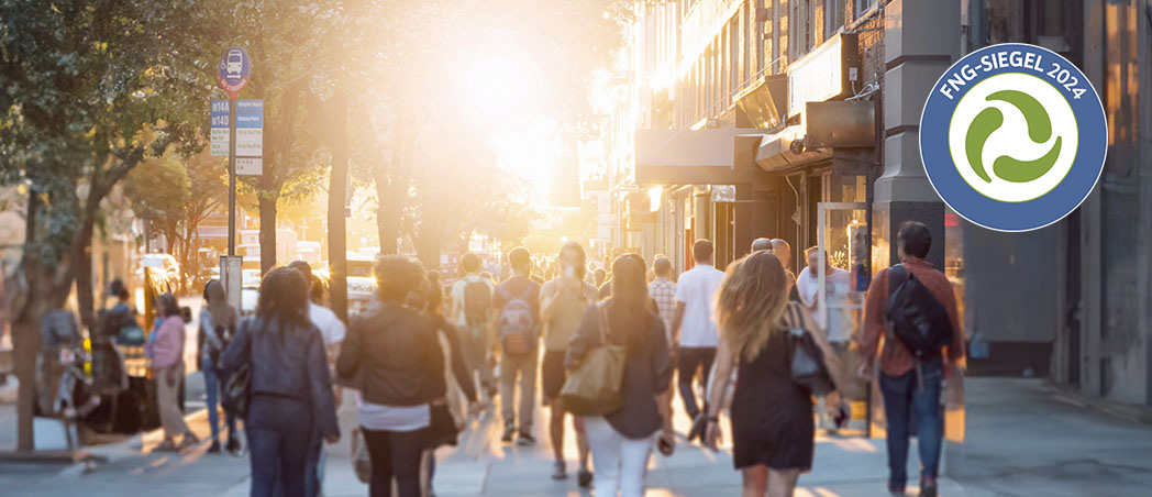 Eine sonnige und belebte Einkaufsstraße mit vielen Menschen