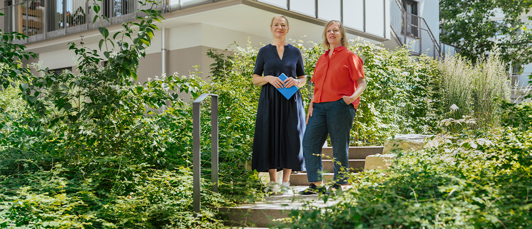 Frauen stehen vor einem nachverdichteten Wohngebäude