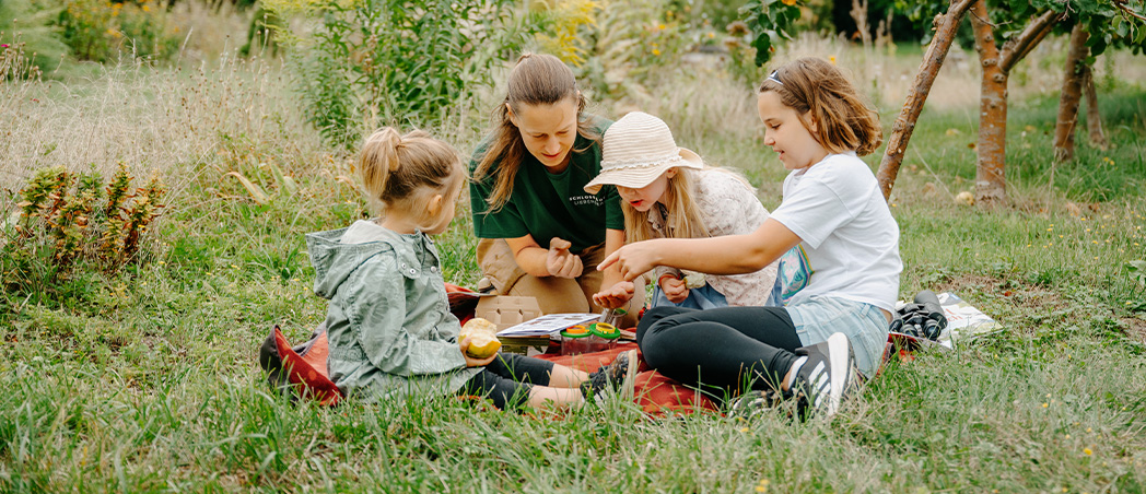 Kinder sitzen auf Wiese