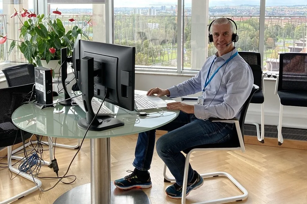 Torsten sitzt an Schreibtisch in Büro mit Blick auf Dresden 