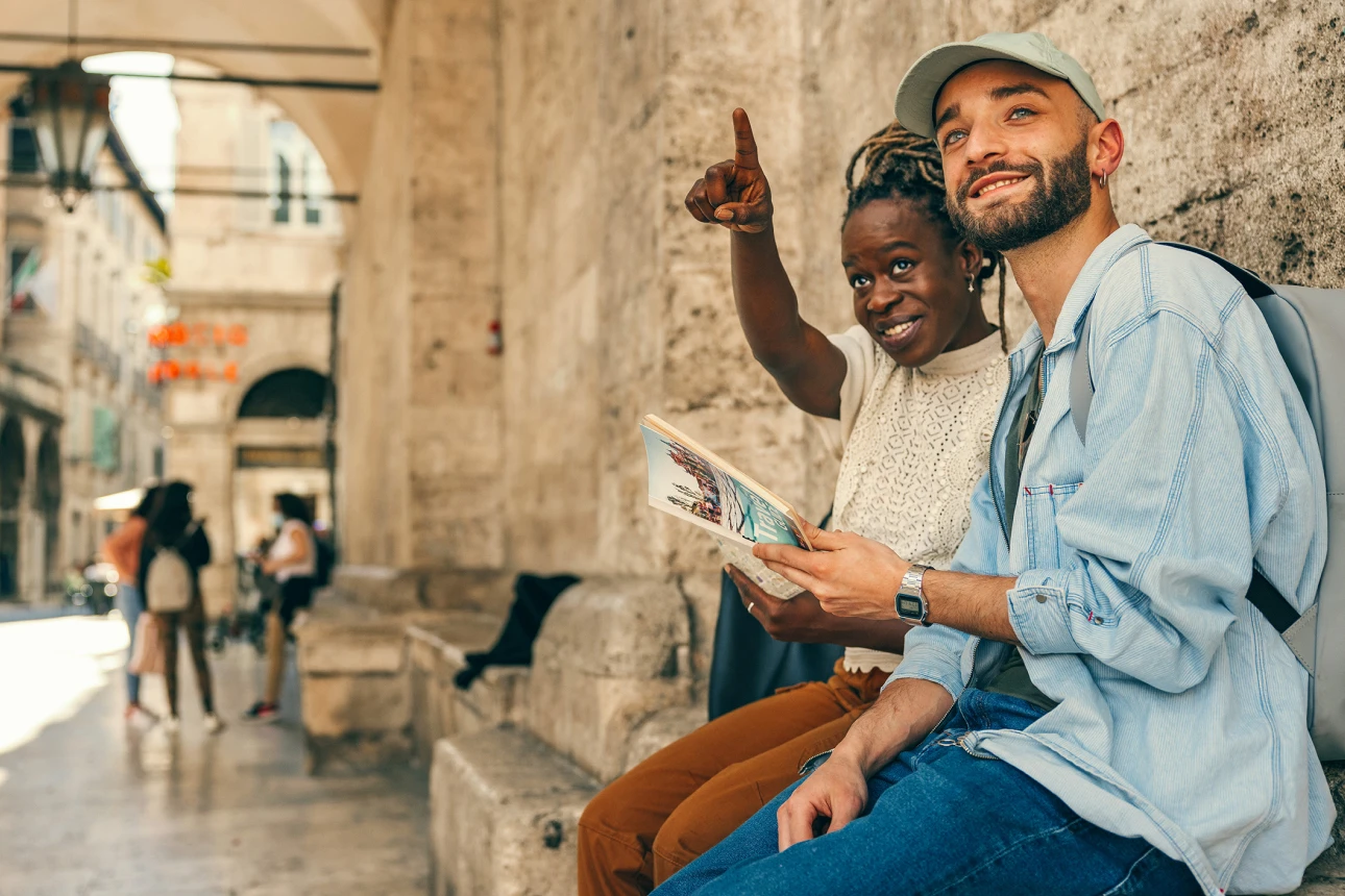 Eine Frau und ein Mann mit einem Reiseführer in der Hand