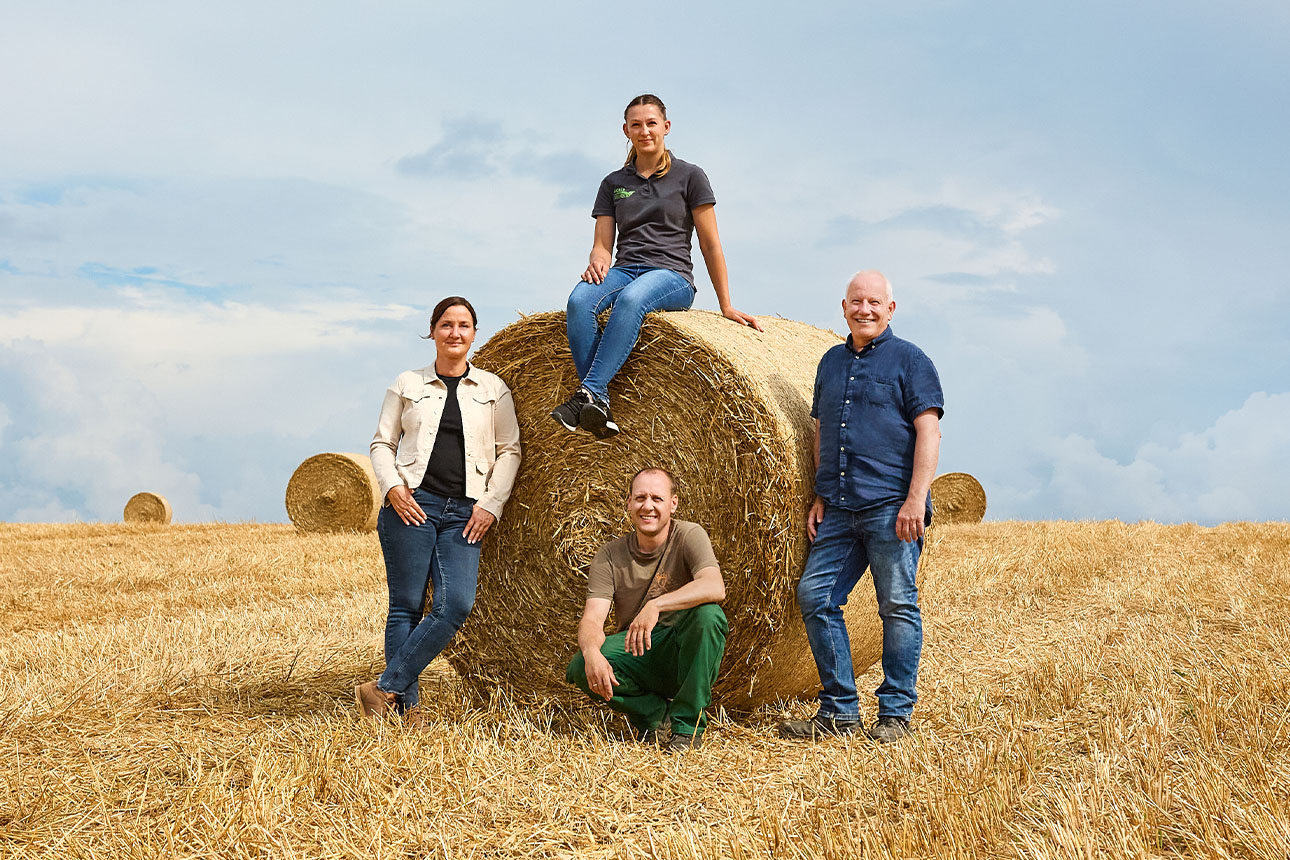 Kunden und Kundenberater vor einem Heuballen