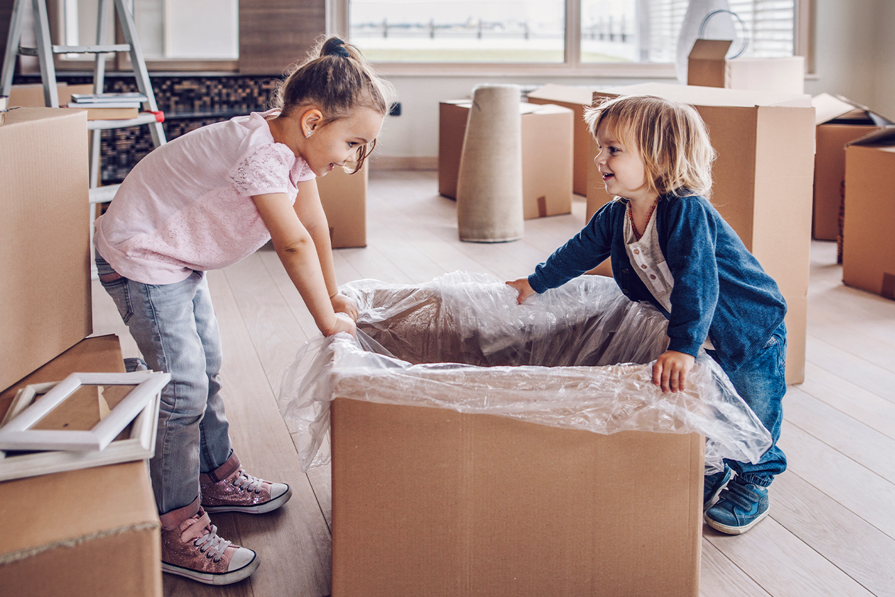 Zwei Kinder zwischen Umzugskartons