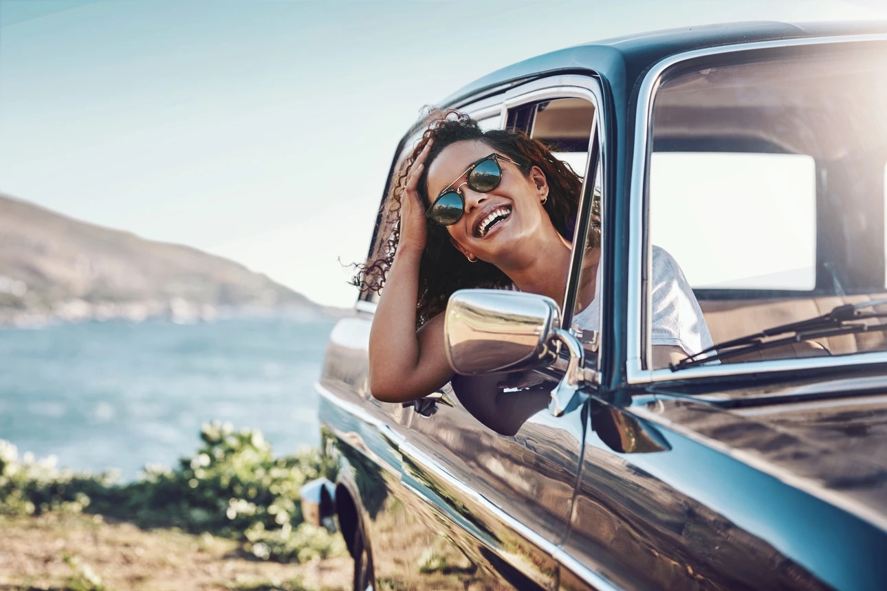 Lachende Frau im Auto sitzend