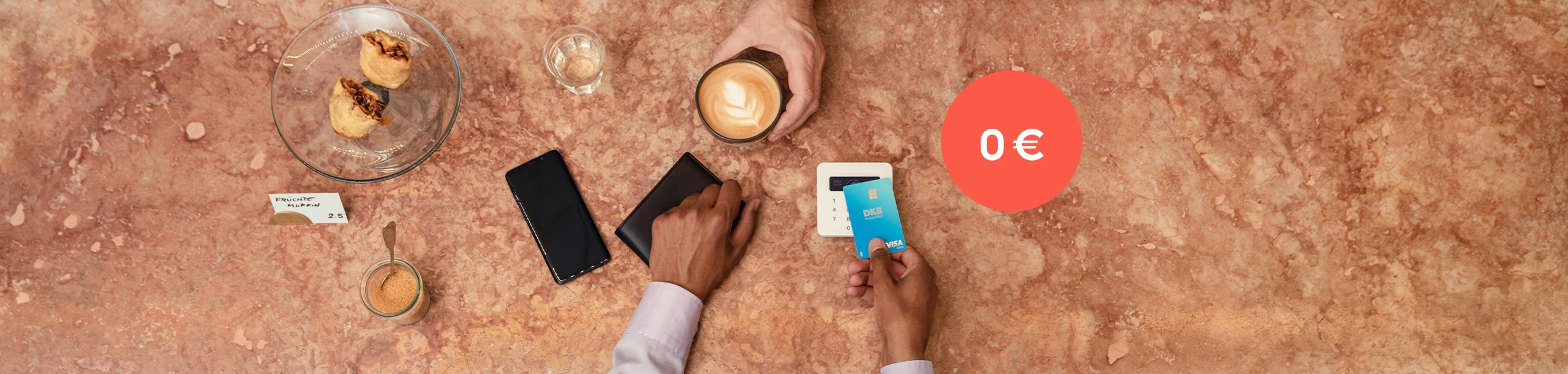 Eine Frau bezahlt ihren Kaffee mit der Visa Debitkarte der DKB