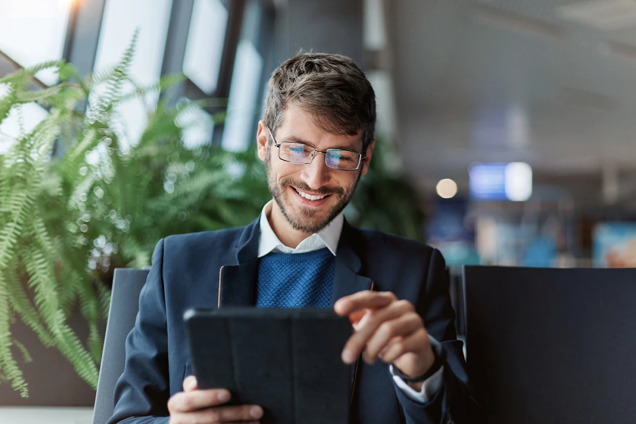 Ein Mann sitzt in einem Stuhl mit einem Tablet in der Hand
