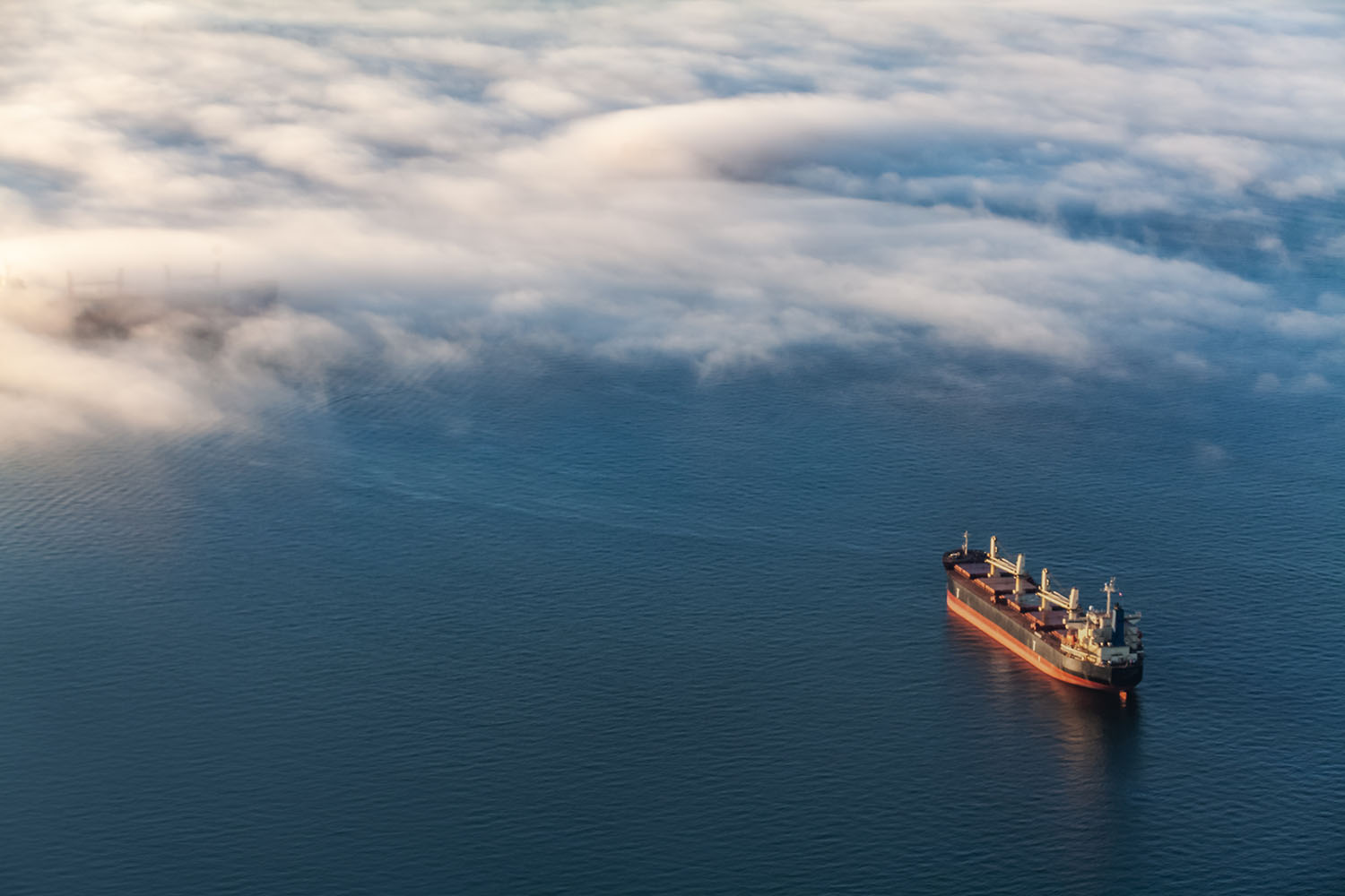 Bulk vessel at sea in low cloud