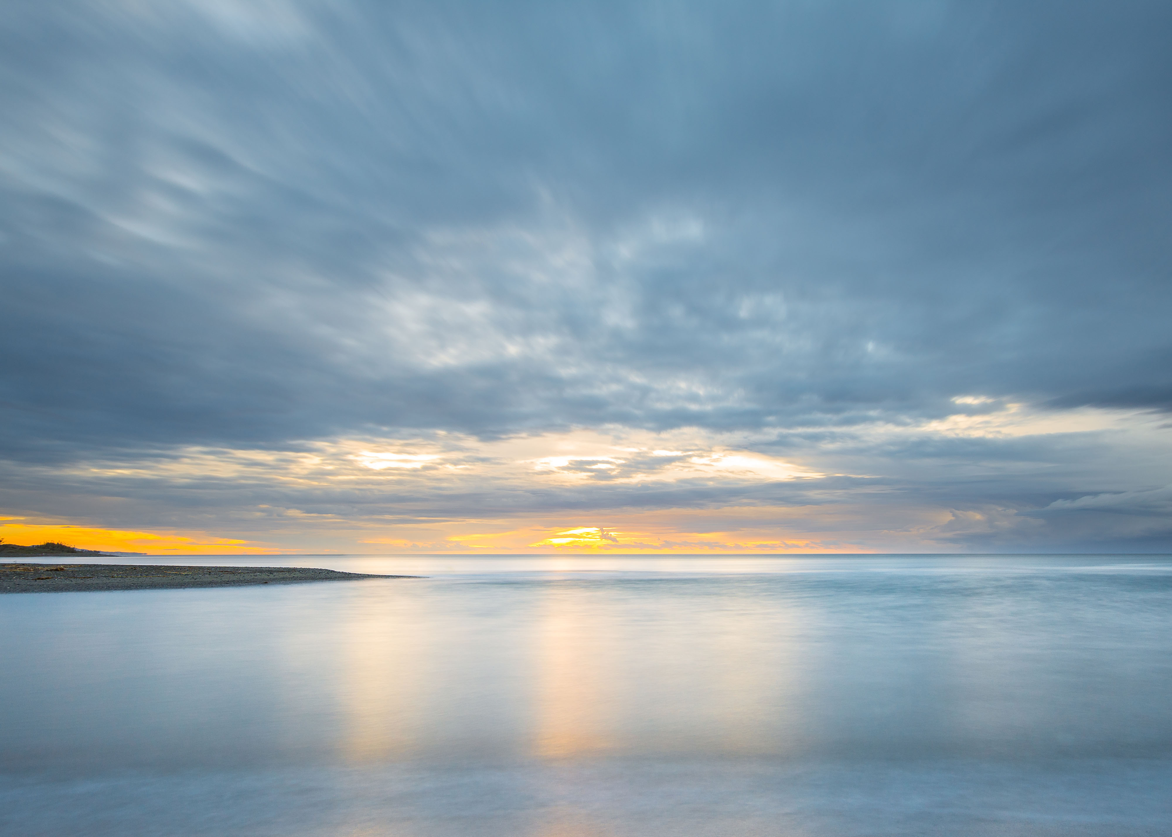 Picture of the sea with a sunrise at dusk with clouds