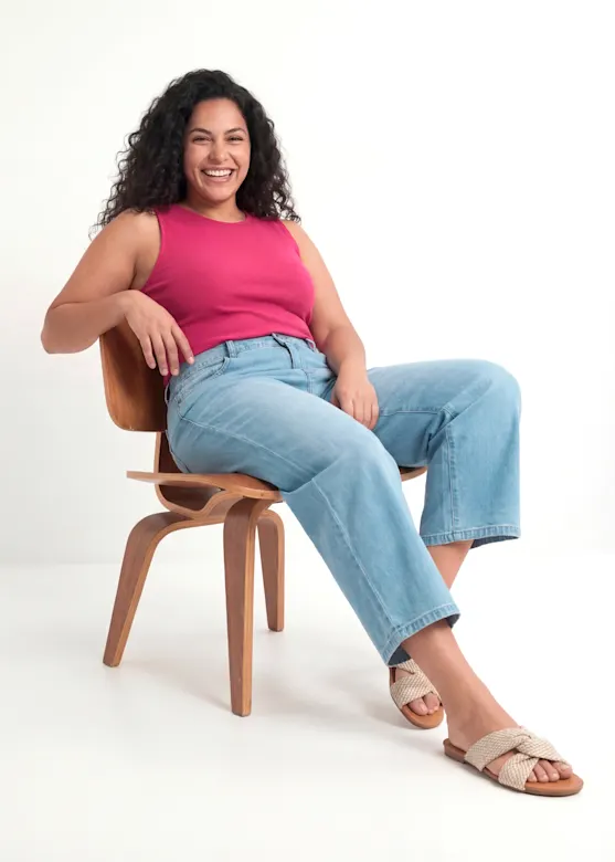 Her outfit: a pink vest top, loose-fitting jeans and woven sandals.