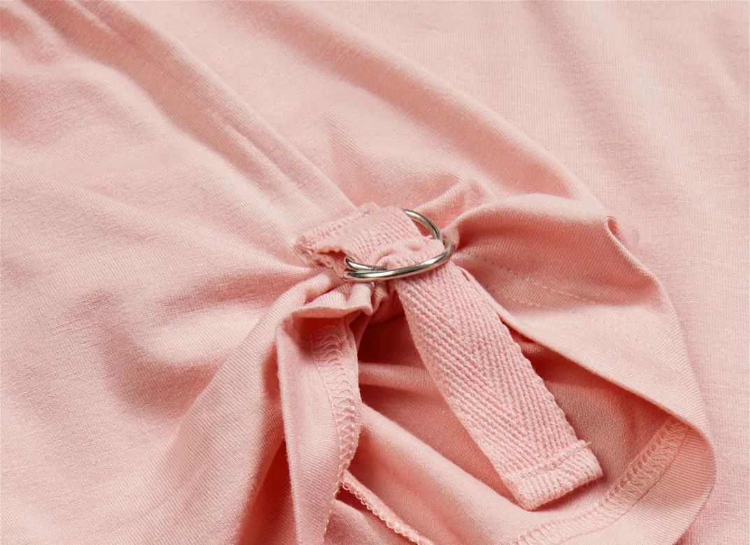 Zartrosa Stoff mit eleganter Schleife. Weiche Textur und sanfte Falten im Textil.