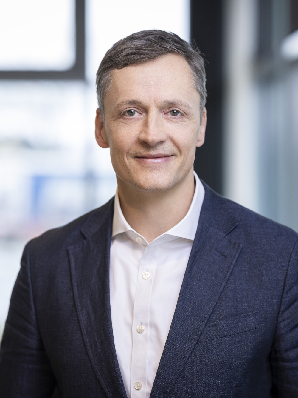 Kai Havekost trägt einen Anzug und lächelt