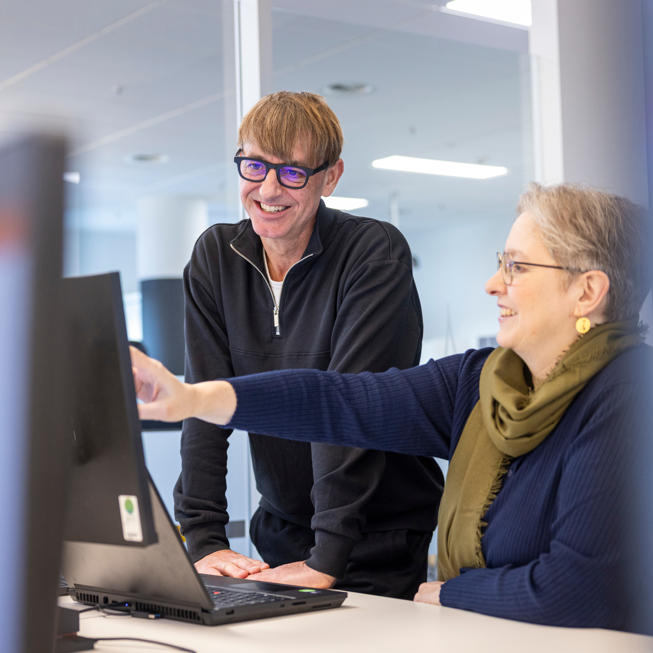 Office situation with two staff members at one computer screen
