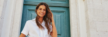 Eine weiße Bluse mit V-Ausschnitt und kurzen Ärmeln verleiht dem Outfit einen frischen, sommerlichen Look.