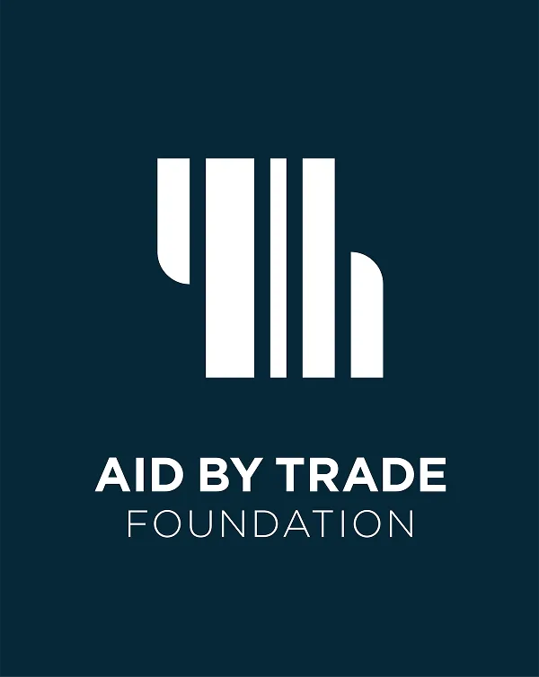 Das Logo der Aid by Trade Foundation, in Weiß auf dunklem Hintergrund.