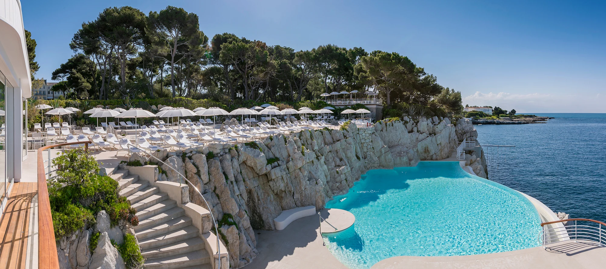 The Eden-Roc pool and white parasols along the rocks