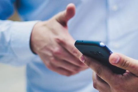 Afbeelding van handen en een telefoon