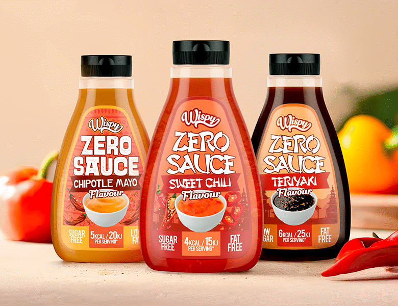 Tre Wispy Nutrition Sauce med forskellige smag ved siden af hinanden. Der ses peberfrugter i baggrunden og chili forrest til højre i billedet. Baggrund og underflade er meget lys lyserød.