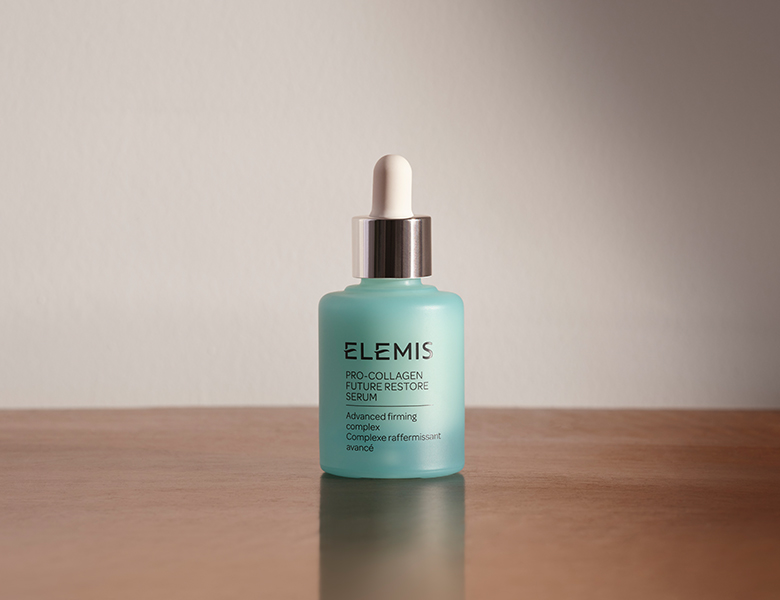 Her ses et ELEMIS serum i en glasflaske med pipette på en lys baggrund.