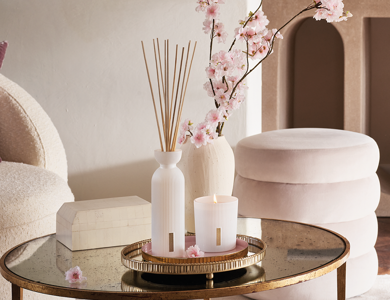 Her ses en æstetisk stue med et duftlys og nogle duftpinde fra Rituals.