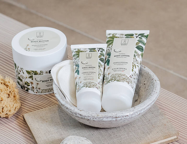 Her ses to hvide og blomstrede produkter ligge i en lys stenskål. Ved siden af står et større hvidt og blomstret produkt. 